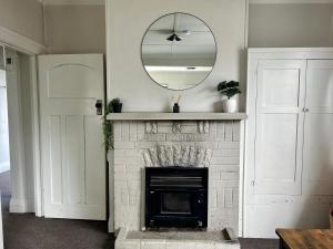 a living room with a fireplace with a mirror at Oamaru Villa in Oamaru