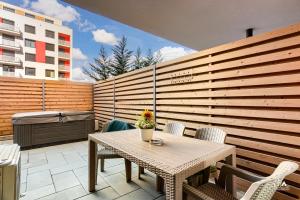 a patio with a table and chairs and a building at Sika Garden Apartment- garaj privat cu intrare direct in apartament și grădină in Arad