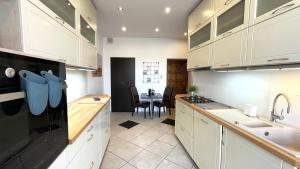 a kitchen with white cabinets and a dining room at Apartament Świętojańska in Gdynia