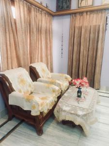 2 chaises et une table avec un vase de fleurs dans l'établissement Bikaner bliss - guest suite, à Bikaner