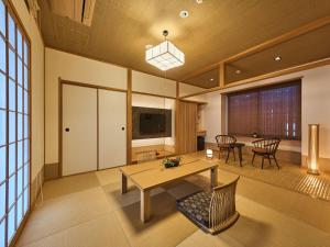 een grote woonkamer met een tafel en stoelen bij Wakasa Annex in Nara