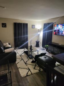 uma sala de estar com um sofá e uma televisão em kaysgroove em Alexandria