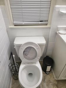 a small bathroom with a white toilet with a window at kaysgroove in Alexandria