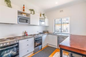 a kitchen with white cabinets and stainless steel appliances at K2 Brisbane in Brisbane