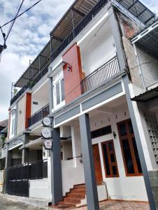 a white building with stairs and a balcony at Ador 46 Homestay Syariah & Kost in Mergan