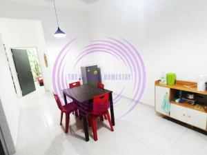 a dining room with a table and a target on the wall at The Clemira Homestay @ Sungai Karangan, Kulim, Kedah in Padang Serai