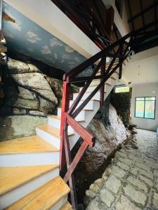 a set of stairs in a room with a stone wall at Anaas Motel in Deniyaya