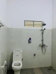 a bathroom with a white toilet in a room at Anaas Motel in Deniyaya