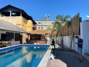 a man standing next to a swimming pool with a dog at Revolution Chiang Mai - Old Town in Chiang Mai