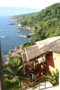 ein Gebäude mit Blick auf das Meer und ein Resort in der Unterkunft Pousada Singuitta - Ilhabela in Ilhabela