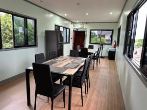 uma sala de jantar com mesa, cadeiras e janelas em Althea Apartelle em Moalboal