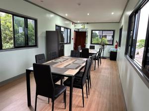 a dining room with a table and chairs and windows at Althea Apartelle in Moalboal