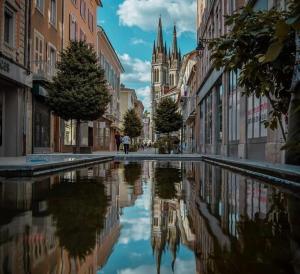 a city street with a reflection in a pool of water at Appart chartreux baignoire massante ,à 2 minutes du centre! in Voiron