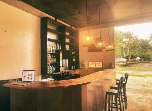a bar with chairs and a laptop on a counter at Villa Malinao Oceanview Resort- Superior Bungalow in Burgos