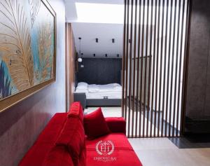Sofá rojo en una habitación con dormitorio en HOTEL EMROVIC RAJ, en Novi Pazar