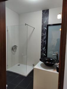 uma casa de banho com uma cabina de duche em vidro e um lavatório. em Joseluce em Gudja