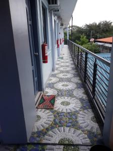 a walkway with a mosaic tile floor next to a building at Althea Apartelle in Moalboal