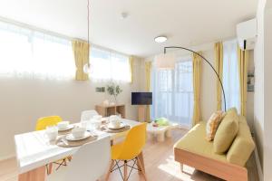 a living room with a table and yellow chairs at EveryNet ShinjukuⅡ in Tokyo