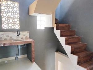 a bathroom with a staircase with a sink and a sink at U Eleven Syariah Homestay in Rawarotan