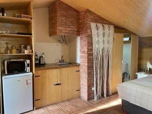 a kitchen with a refrigerator and a sink in a room at Cal General in San Vicente de Castellet