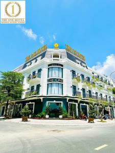 Cà Mau的住宿－Khách Sạn The One Hotel 1，白色的建筑,上面有标志