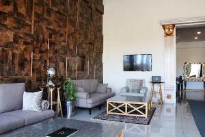 uma sala de estar com sofás e uma parede de pedra em Grande Deluxe Luxury Apartment em Rawalpindi