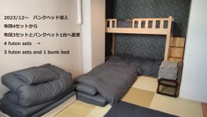 Habitación pequeña con litera y sofá en Oyado Kien Ryogoku, en Tokio