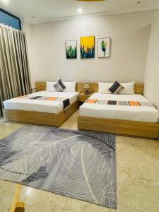 2 Betten in einem Zimmer mit 2 Schlafgelegenheiten in der Unterkunft Khách Sạn The One Hotel 1 in Cà Mau