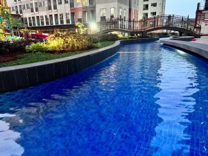 una grande piscina blu in una città di notte di Transpark Juanda by Bonzela Property a Padurenan