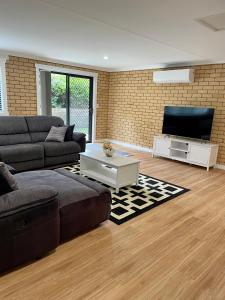 a living room with a couch and a flat screen tv at Sandstone Family Apartment in Grindelwald