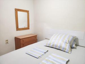 a bedroom with a bed with a mirror and two napkins at Acogedor y competo apartamento. in Villajoyosa