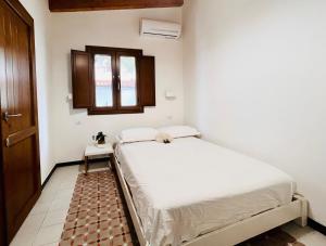 une petite chambre avec un lit et une fenêtre dans l'établissement Splendida Casa - 50 metri dal mare, à Portoscuso