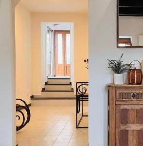 un couloir avec une porte et une table ornée de plantes dans l'établissement Splendida Casa - 50 metri dal mare, à Portoscuso