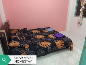Łóżko lub łóżka w pokoju w obiekcie Sinar Maju Homestay