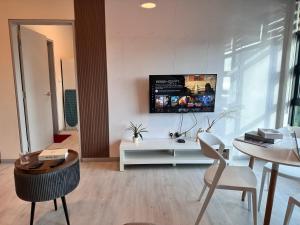 sala de estar con TV en una pared blanca en JQ1 SEA & POOL or CITY View WIFI I WASHING MACHINE for Seaview unit I CUCKOO WATER Jesselton Quay by R2, en Kota Kinabalu