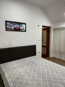 - une chambre dotée d'un lit avec une photo sur le mur dans l'établissement Къща за гости Арнаудови, à Kostandovo