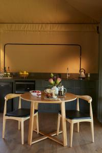 una mesa y 2 sillas en una cocina en Olio Bello Lakeside Glamping, en Cowaramup