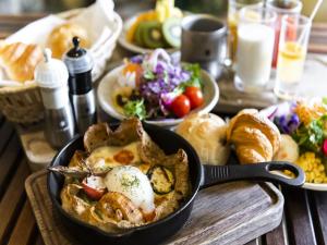 a table topped with a pan filled with food and bread at HOTEL MYSTAYS PREMIER Sapporo Park in Sapporo
