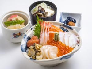 a bowl of sushi and other bowls of food at HOTEL MYSTAYS PREMIER Sapporo Park in Sapporo