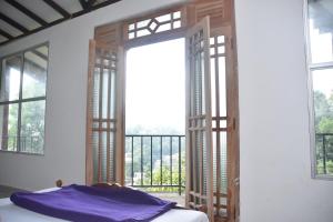 a bedroom with a door open to a balcony at Mountain View in Bandarawela