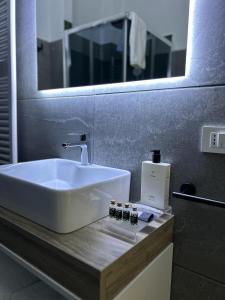 a bathroom with a white sink and a mirror at Zeta Rooms in Caserta