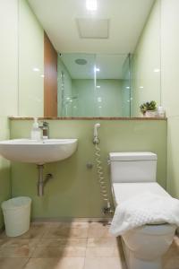 a bathroom with a toilet and a sink and a mirror at Soho Suites KLCC by Leala in Kuala Lumpur