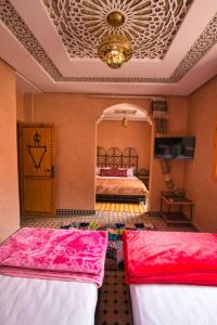een slaapkamer met 2 bedden en een kroonluchter bij DAR NOUR in Tafraoute