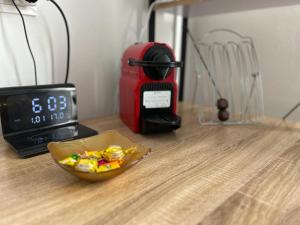 un bol de bonbons sur une table à côté d'une horloge dans l'établissement Zeta Rooms, à Caserte