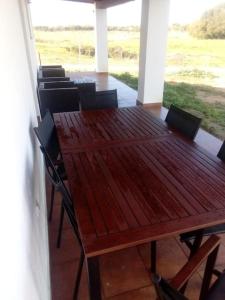 una mesa de madera y sillas en una habitación en Refugio rural cerca de El Rocio- El flamenco azul en Almonte