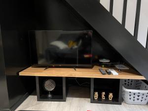 a tv sitting on top of a wooden table at Maison avec jardin in Le Grau-du-Roi