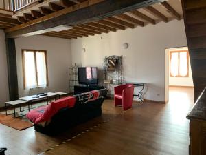 a living room with a couch and a tv at Le Nid in Éclaron