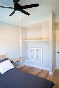 um quarto com uma cama e uma ventoinha de tecto em Island in the Hills Modern Poolside Home in San Diego em San Diego