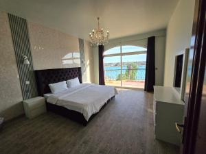 ein Schlafzimmer mit einem Bett und einem großen Fenster in der Unterkunft فيلا على البحر بمسبح خاص وشاطى رملي in Durrat Al-Arus