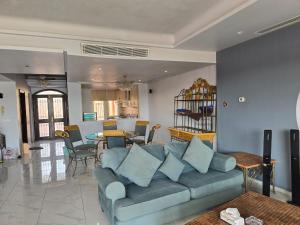ein Wohnzimmer mit einem blauen Sofa und einem Tisch in der Unterkunft فيلا على البحر بمسبح خاص وشاطى رملي in Durrat Al-Arus